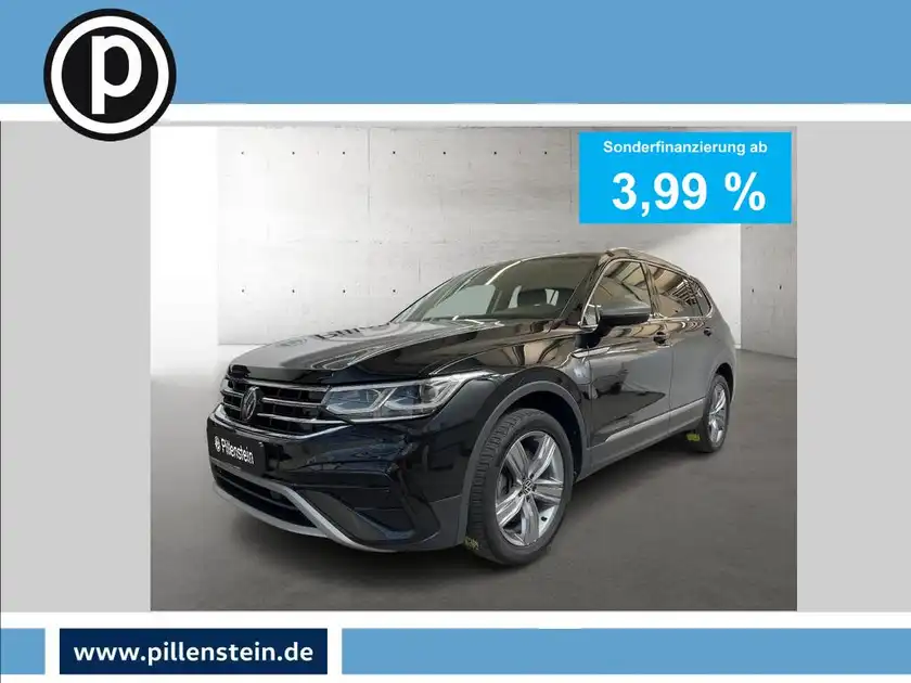 Das Bild zeigt einen schwarzen VW Tiguan Allspace von der Seite. Es enthält eine Anzeige mit der Sonderfinanzierung ab 3,99 % und das Händlerlogo.
