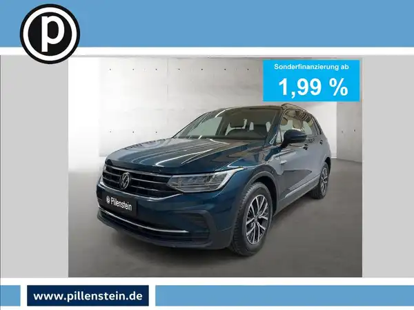 Das Bild zeigt einen blauen VW Tiguan aus der Frontansicht. Es enthält eine Texteinblendung für eine Sonderfinanzierung von 1,99 % und ein Händlerinformationslogo.