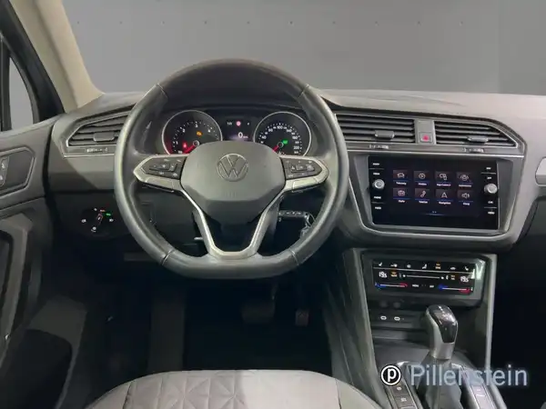 Innenaufnahme eines VW Tiguan mit schwarzem Interieur und angezeigtem Händlerlogo.