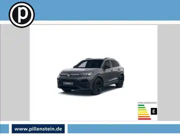 Das Bild zeigt einen schwarzen VW TIGUAN aus der Frontalansicht. Oben links ist das Händlerlogo eingeblendet. Unten rechts sind markante Texteinblendungen zu sehen.