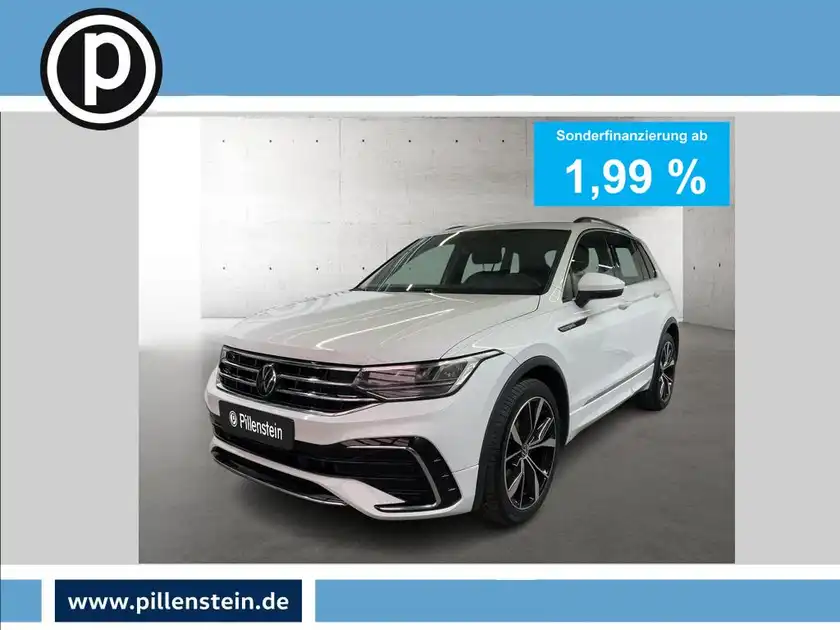 Das Bild zeigt einen weißen VW Tiguan von vorne in einem Studio mit einem Werbebanner, das Sonderfinanzierung zu 3,99 % anzeigt. Der Händlerlogo ist sichtbar.