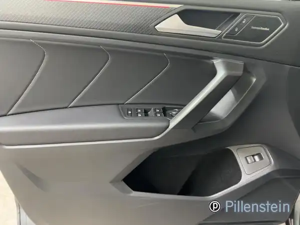 Innenaufnahme des Fahrzeugs VW Tiguan Allspace, Türverkleidung in Schwarz mit roten Akzenten.