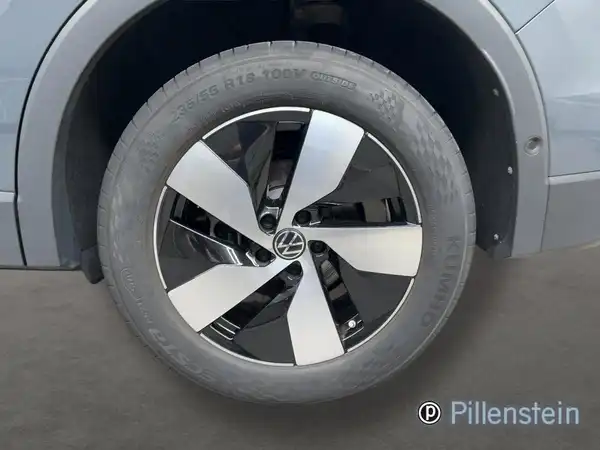 Das Bild zeigt das Innere eines VW Tiguan. Das Interieur ist in Schwarz gehalten. Es gibt ein Händlerlogo im Bild.