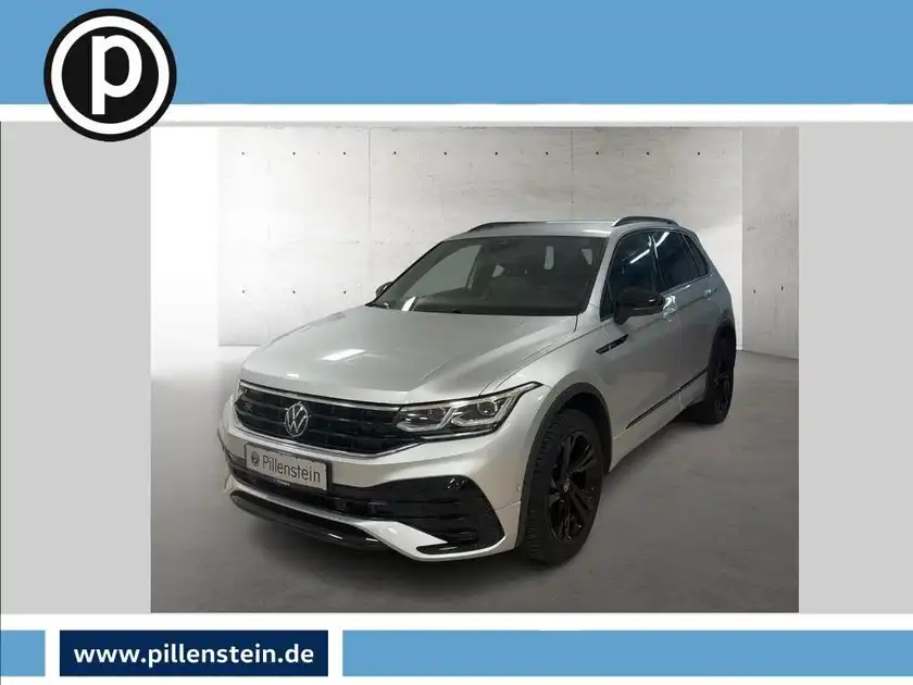 Das Bild zeigt einen silbernen VW Tiguan von vorne. Das Händlersymbol ist oben links sichtbar und es gibt markante Texteinblendungen.