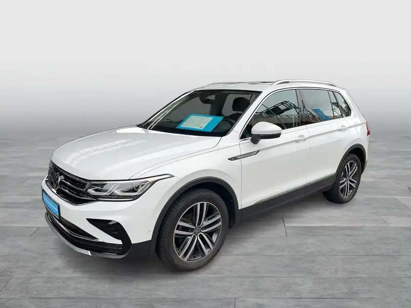 Das Bild zeigt einen weißen VW Tiguan von der Seite. Es enthält markante Texteinblendungen und kein Händlerlogo.
