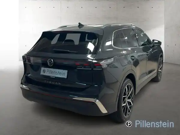 Das Bild zeigt einen VW Tiguan, aufgenommen von hinten. Das Fahrzeug ist schwarz und trägt das Händlerlogo von Pillenstein.