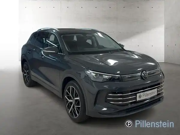 Das Bild zeigt einen grauen VW Tiguan aus der Seitenansicht mit dem Händlerinlogo "Pillenstein".