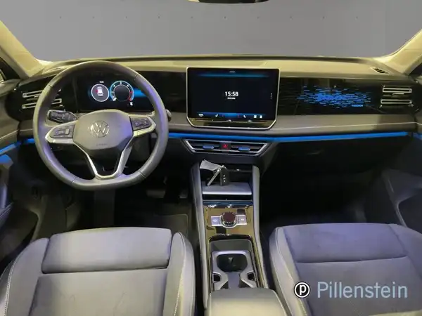 Eine Innenaufnahme eines VW Tiguan, mit einem dunkeltblauen und hellgrauen Interieur. Das Händlerlogo ist eingeblendet.