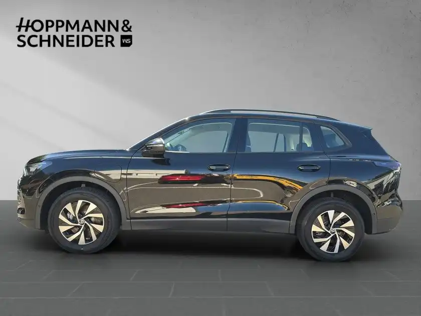 Seitenansicht eines schwarzen VW Tiguan, aufgenommen in einem Studio mit dem Händlerlogo HOPPMANN & SCHNEIDER im Bild.