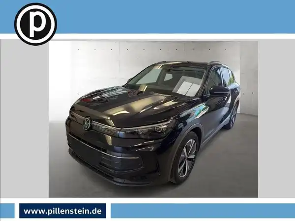 Das Bild zeigt einen schwarzen Volkswagen Tiguan, aufgenommen von vorne. Im Bild ist das Händlerlogo zu sehen und es gibt markante Texteinblendungen.