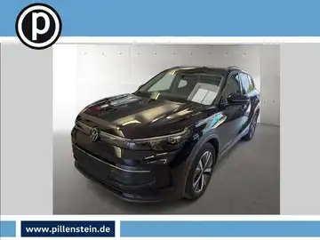 Das Bild zeigt einen schwarzen Volkswagen Tiguan, aufgenommen von vorne. Im Bild ist das Händlerlogo zu sehen und es gibt markante Texteinblendungen.