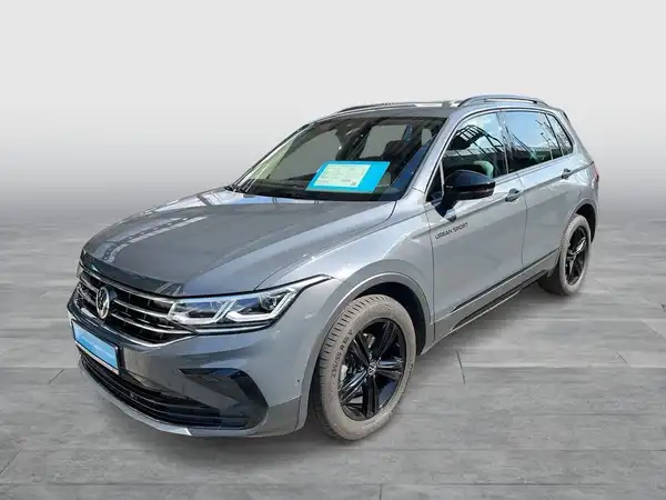 Das Bild zeigt einen grauen VW Tiguan aus der Seitenansicht. Es gibt markante Texteinblendungen im Bild.