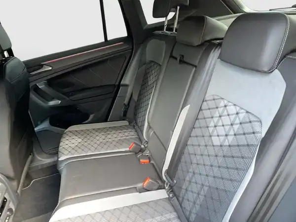 Das Bild zeigt den Innenraum des VW TIGUAN, speziell die Rücksitzbank in schwarzer Farbe mit grauen und gesteppten Akzenten.