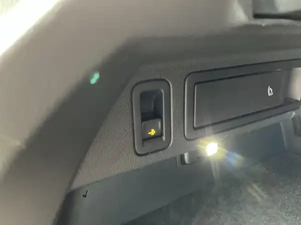 Das Bild zeigt eine Innenaufnahme des Fahrzeugs mit einem schwarzen Interieur, das einen Knopf und eine kleine Lampe enthält. Es handelt sich um einen Blick auf die Fahrzeug-Innenausstattung.