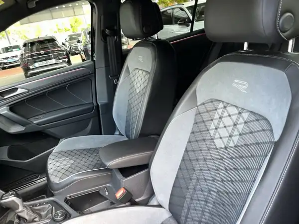 Das Bild zeigt den Innenraum eines VW Tiguan mit schwarzen und grauen Sitzen, die ein gestepptes Design aufweisen.