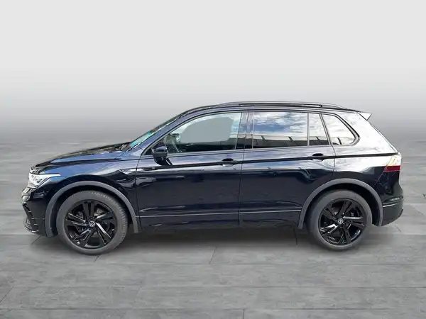 Das Bild zeigt einen VW Tiguan in schwarzer Farbe, aufgenommen von der Seite.