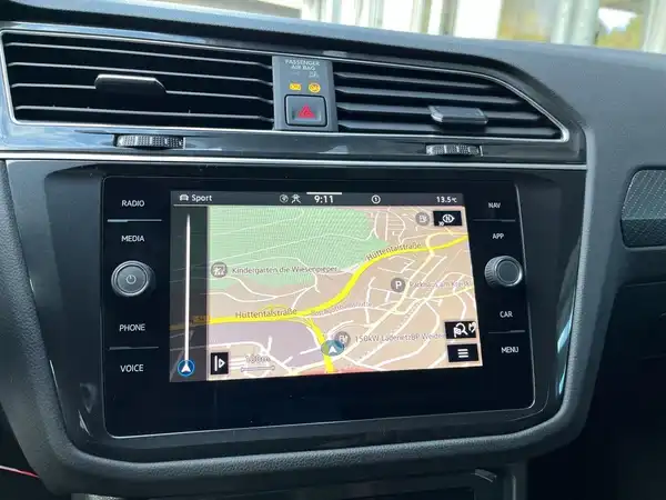 Das Bild zeigt das Navigationsdisplay im Innenraum eines VW Tiguan, die Interieurfarbe ist schwarz.