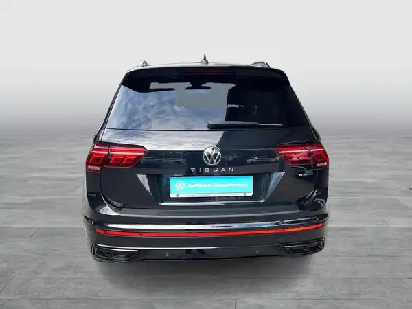 Das Bild zeigt die Rückansicht eines schwarz lackierten VW Tiguan.
