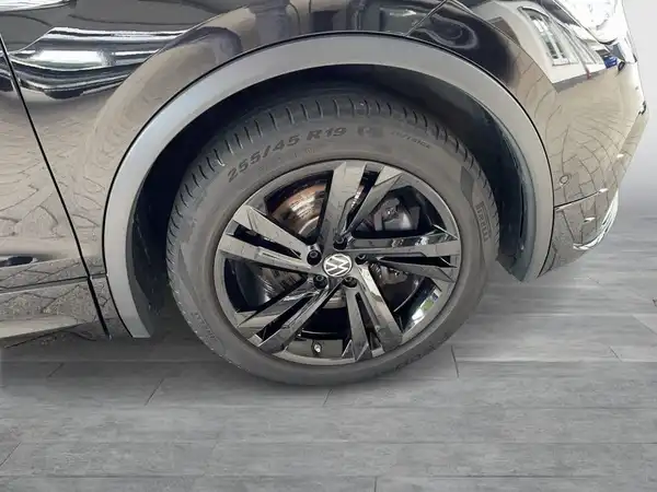 Das Bild zeigt seitlich einen schwarzen VW Tiguan mit einem detailierten Blick auf das Rad und die Felge.