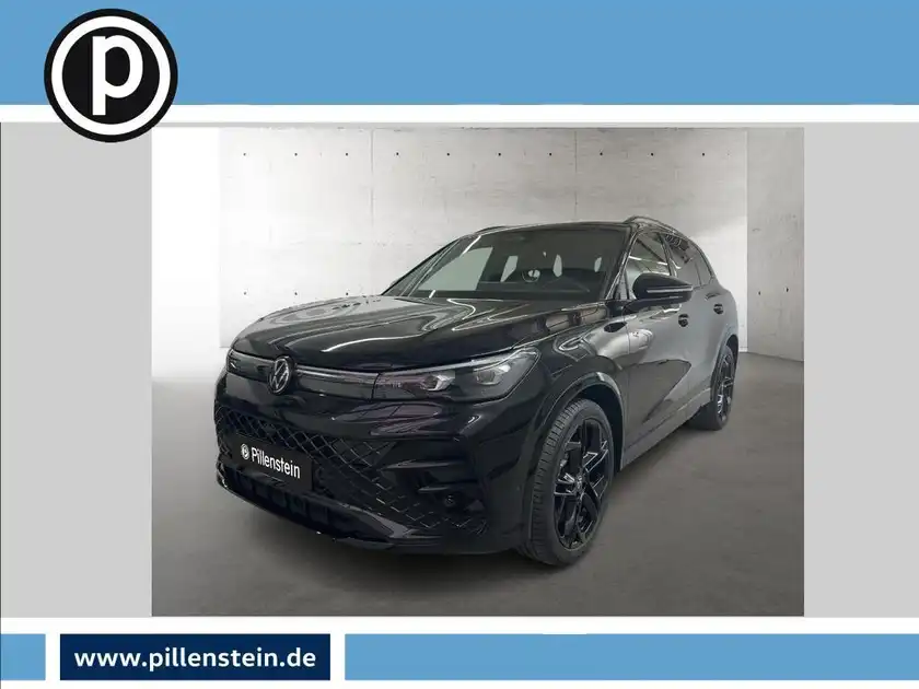 Das Bild zeigt ein schwarzes Fahrzeug (VW Tiguan) aus seitlicher Perspektive. Im Bild ist das Händlerlogo deutlich sichtbar und es gibt markante Texteinblendungen.
