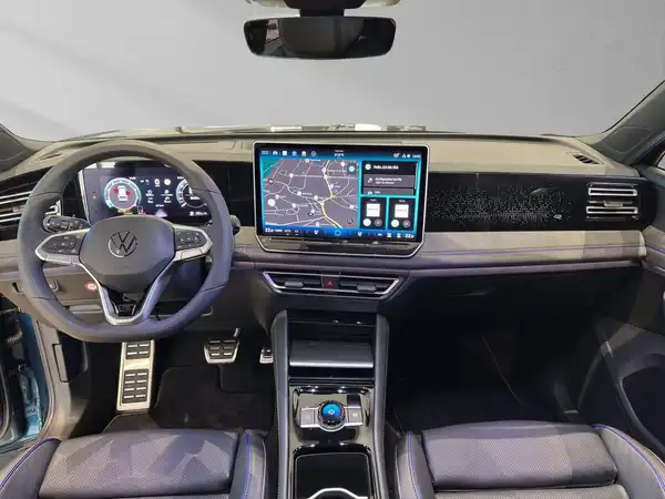 Das Bild zeigt das Innere eines VW Tiguan, mit einem schwarzen Interieur und modernen Displays.