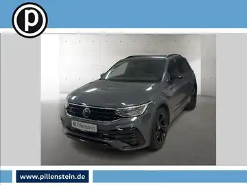 Das Bild zeigt einen grauen VW Tiguan aus Frontalansicht. Es ist ein Fahrzeugbild, das das Händlerlogo enthält und markante Texteinblendungen aufzeigt.