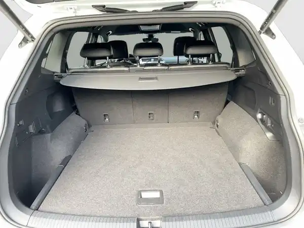Das Bild zeigt den Innenraum des Kofferraums eines VW Tiguan Allspace in grauer Farbe.