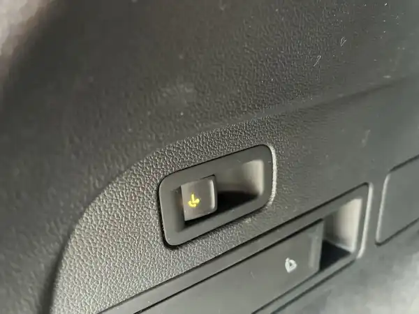 Nahaufnahme des Innenraums eines VW Tiguan Allspace mit einem Schalter und einer Ablage.