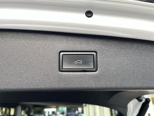 Aufnahme des Innenraums eines VW Tiguan Allspace, mit einer schwarzen Innenfläche, die einen Kofferraumschalter zeigt.