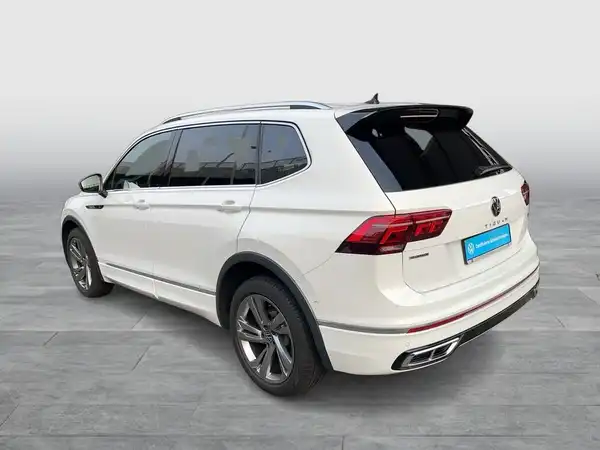 Das Bild zeigt einen weißen VW Tiguan Allspace, aufgenommen von der Seite.