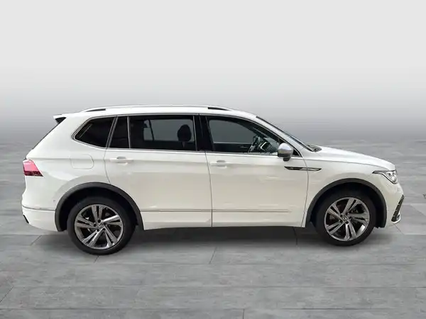 Das Bild zeigt einen weißen VW Tiguan Allspace von der Seite.