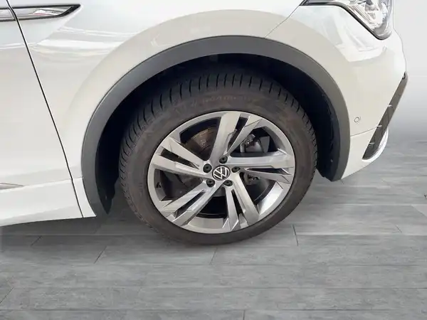 Seitenansicht eines weißen VW TIGUAN. Das Bild zeigt das Rad und einen Teil der Karosserie.