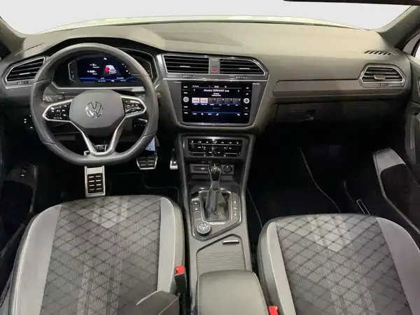 Das Bild zeigt den Innenraum eines VW Tiguan Allspace aus der Innenaufnahme. Die Sitze sind schwarz mit einem strukturierten Muster.
