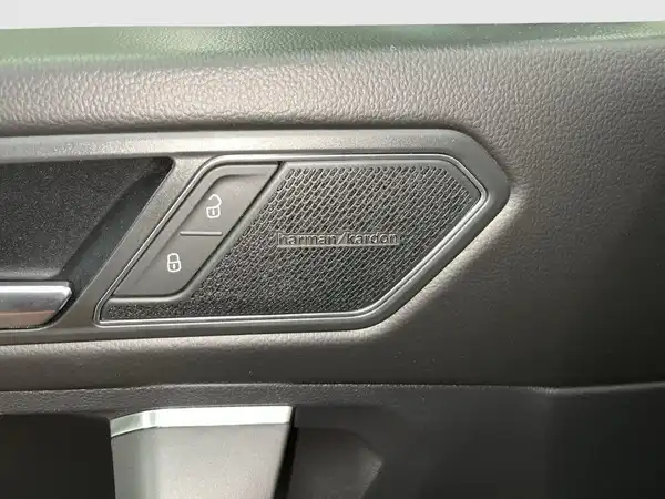 Das Bild zeigt das Innenraumdetail eines VW Tiguan Allspace, aufgenommen von innen, mit einem schwarzen Interieur. Es enthält Texteinblendungen.