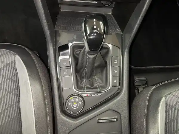 Eine Innenaufnahme des Fahrzeugs, die den Schalthebel und die Mittelkonsole zeigt. Das Interieur ist in Schwarz.