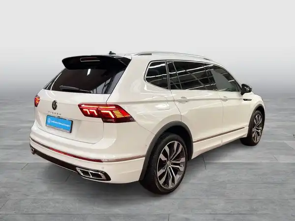 Das Bild zeigt einen weißen VW Tiguan Allspace aus der Rückansicht.