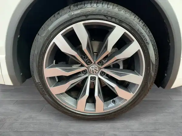 Das Bild zeigt einen seitlichen Blick auf eine Felge eines weißen VW Tiguan Allspace.
