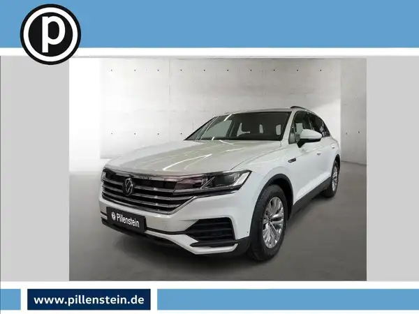 Das Bild zeigt ein weißes Fahrzeug, einen VW Touareg, aus der Frontansicht. Es enthält das Händlerlogo und markante Texteinblendungen.