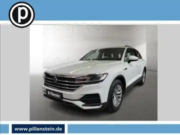 Das Bild zeigt ein weißes Fahrzeug, einen VW Touareg, aus der Frontansicht. Es enthält das Händlerlogo und markante Texteinblendungen.