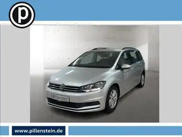 Das Bild zeigt einen silbernen VW Touran von vorne, mit einem kleinen Händlerlogo in der oberen linken Ecke und auffälligen Texteinblendungen.