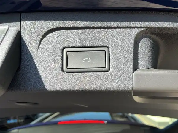 Das Bild zeigt eine Innenaufnahme des VW Touran mit einem Knopf, möglicherweise für die Heckklappe.