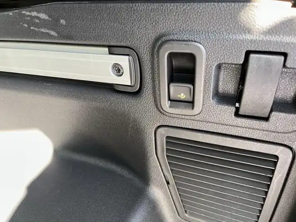 Das Bild zeigt einen Innenraum des VW Touran mit einem schwarzen Kunststoffbereich, der Bedienelemente und einen Lüftungsschlitz enthält.