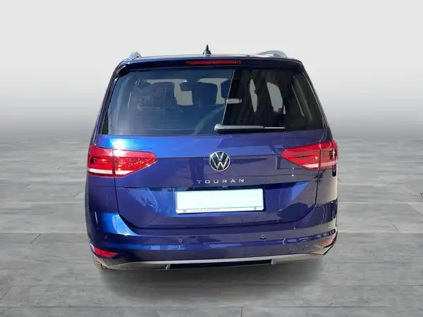 Das Bild zeigt die Rückansicht eines blauen VW Touran.