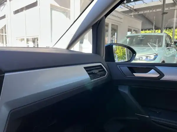 Eine Innenaufnahme des VW Touran mit schwarzem Interieur und silbernen Akzenten.