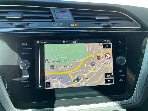 Das Bild zeigt das Navigationssystem im Innenraum eines VW Touran. Es handelt sich um eine Innenaufnahme des Fahrzeugs.