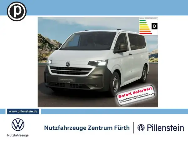 Das Bild zeigt einen weißen VW Transporter aus der Frontalansicht. Im unteren Bereich sind Händlerlogos und ein Hinweis auf die sofortige Lieferbarkeit eingeblendet.