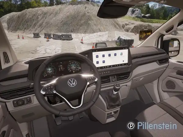 Eine Innenaufnahme des VW Transporter mit einem beigen Interieur. Das Bild zeigt das Armaturenbrett und das Lenkrad.