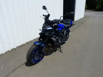 Das Bild zeigt eine YAMAHA MT-09 aus der Seitenansicht, in blauer Farbe, auf einem Asphaltweg.