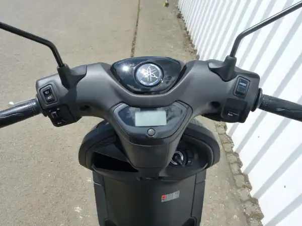 Das Bild zeigt die Innenansicht des Lenkers eines Yamaha NEOs Rollers in schwarzer Farbe. Es gibt kein Händelerlogo oder andere markante Texteinblendungen.
