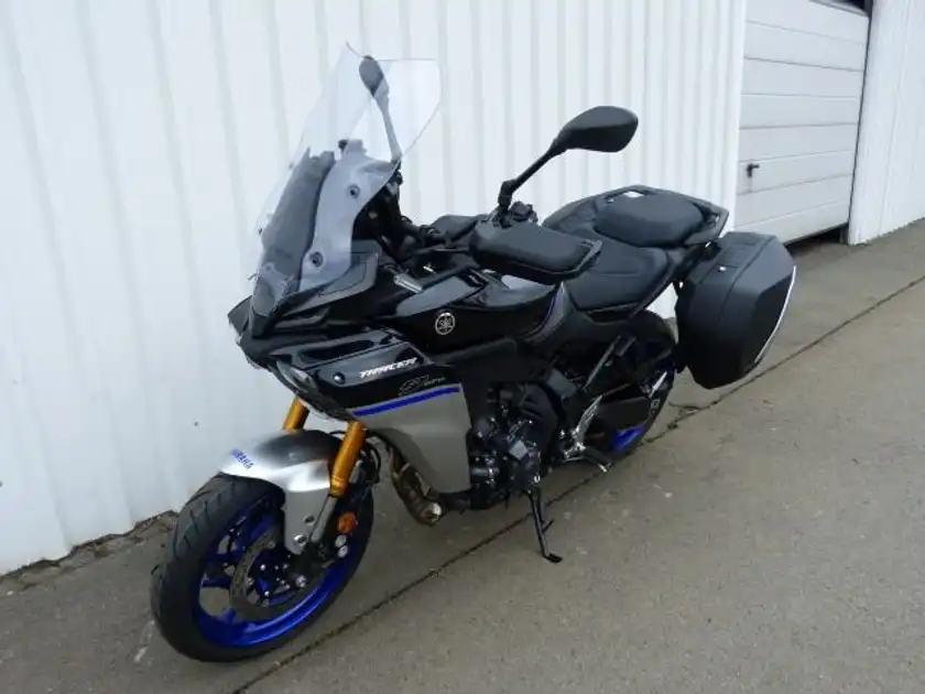 Das Bild zeigt eine Yamaha Tracer 9 von der Seite, in schwarz mit blauen Akzenten.